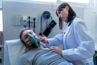 Hastanenin acil servisinde oksijen maskesi olan hasta bir adamla kadın doktor. Sigara ve solunum hastalıklarında ve tütün karşıtı reklam kampanyalarında.