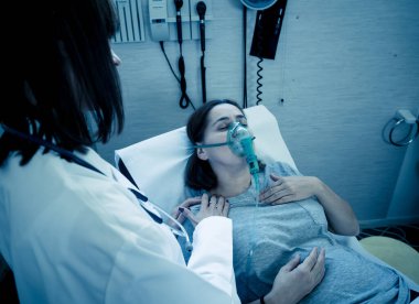 Oksijen maskesi olan genç hasta bir kadın hasta olan kadın doktor acı içinde ve hastanede endişeli görünüyor. Sağlık, sigara ve solunum hastalıklarında ve tütün reklamına karşı kampanyalarda.