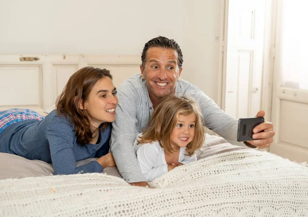快乐的家庭 妈妈爸爸和小女儿 在手机上自拍照片或打电话给家人聊天 在生活方式和技术使用 数字发电和社交媒体方面 — 图库照片