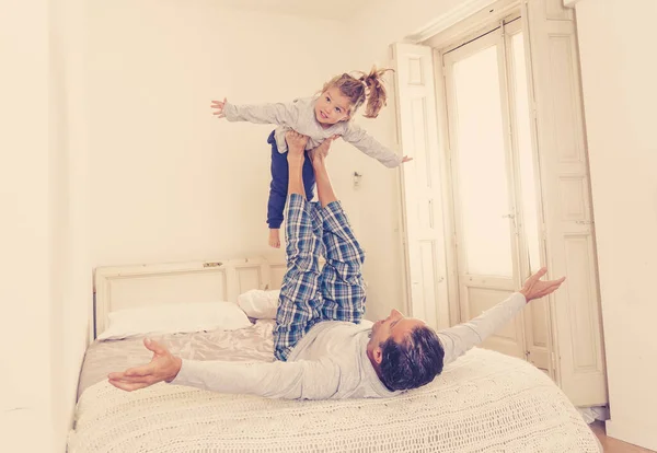 快乐的家庭 父亲和可爱的女儿在床上拥抱 玩耍和欢笑 美丽的小女孩与爸爸在谈情说爱 单亲和教育观念等方面都很开心 — 图库照片