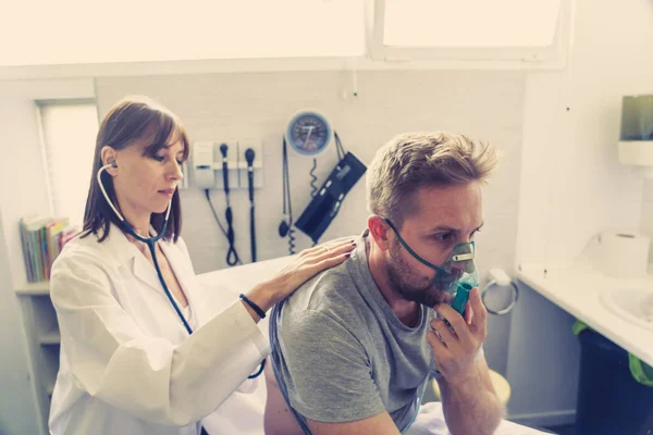 Ung Sjuk Man Patient Med Syrgasmask Medan Kvinnlig Läkare Lyssnar — Stockfoto
