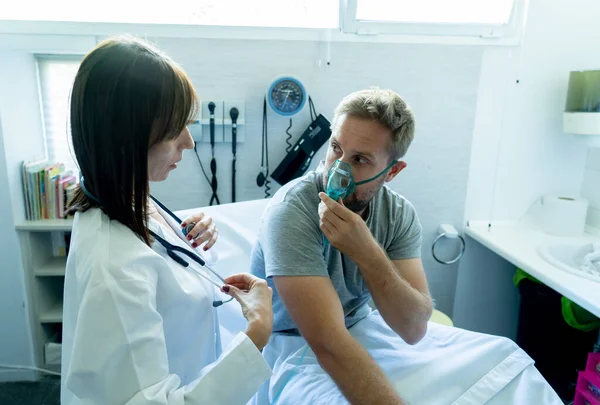 Jonge Zieke Man Patiënt Met Zuurstofmasker Terwijl Vrouwelijke Arts Luistert — Stockfoto