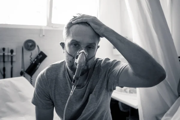 Fiatal Vonzó Férfi Oxigénmaszk Néz Szomorú Aggódik Kórházi Ágyban Klinikán — Stock Fotó
