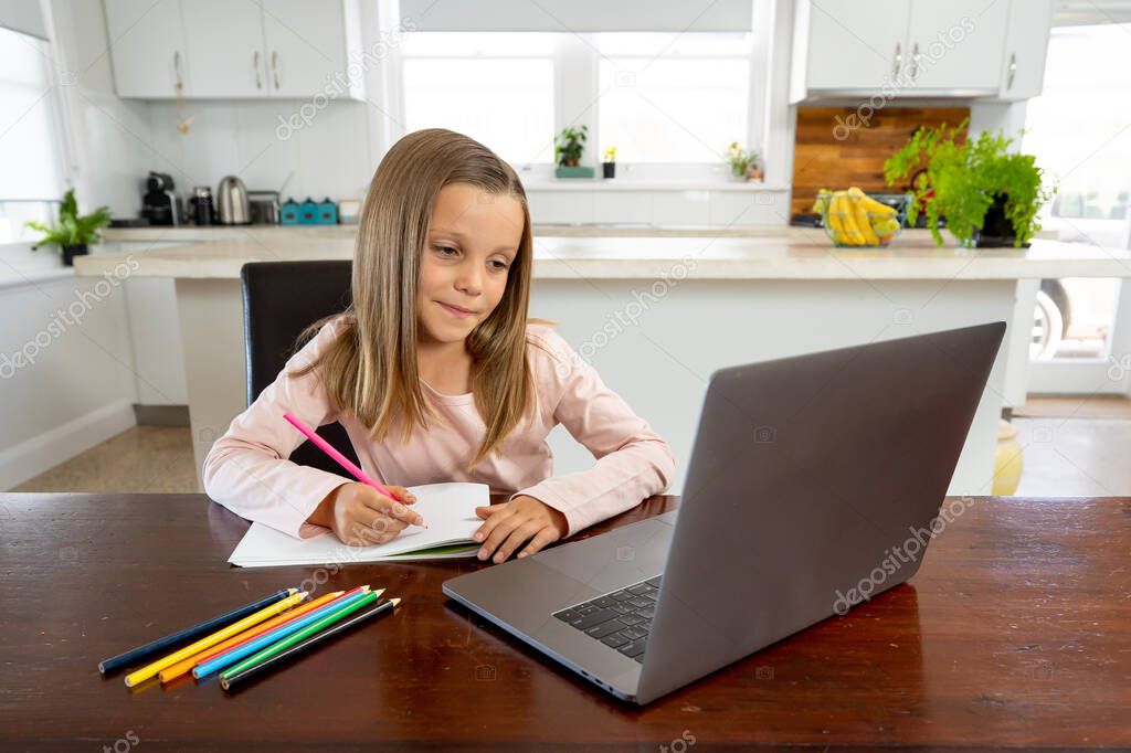 Coronavirus Outbreak. Lockdown and school closures. Schoolgirl watching online education class, happy talking with teacher on the internet at home. COVID-19 pandemic forces children online learning.