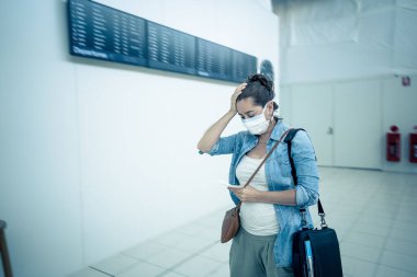 Coronavirus salgını seyahat kısıtlamaları. Uluslararası havaalanında maskeli gezginler uçuşların iptalinden ve seyahat yasağından etkilendiler. COVID-19 salgını dünya çapında sınır kapatma ve kapatma.