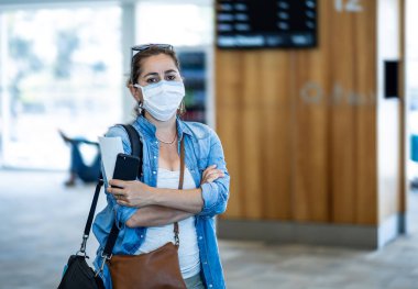Coronavirus salgını seyahat kısıtlamaları. Uluslararası havaalanında maskeli gezginler uçuşların iptalinden ve seyahat yasağından etkilendiler. COVID-19 salgını dünya çapında sınır kapatma ve kapatma.