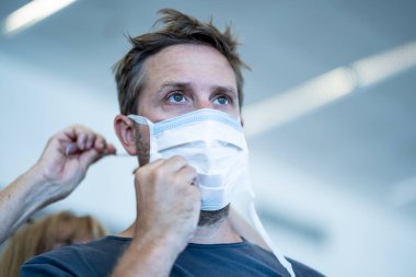 Coronavirus salgını seyahat kısıtlamaları. Uluslararası havaalanında maskeli gezginler uçuşların iptalinden ve seyahat yasağından etkilendiler. COVID-19 salgını dünya çapında sınır kapatma ve kapatma.