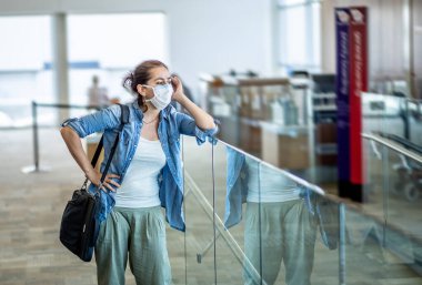 Coronavirus salgını seyahat kısıtlamaları. Uluslararası havaalanında maskeli gezginler uçuşların iptalinden ve seyahat yasağından etkilendiler. COVID-19 salgını dünya çapında sınır kapatma ve kapatma.