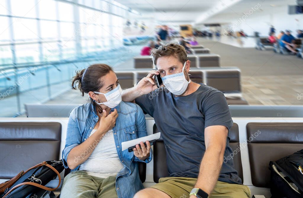 Coronavirus outbreak travel restrictions. Travelers with face mask at international airport affected by flights cancellations and travel ban. COVID-19 pandemic worldwide border closures and shutdowns.