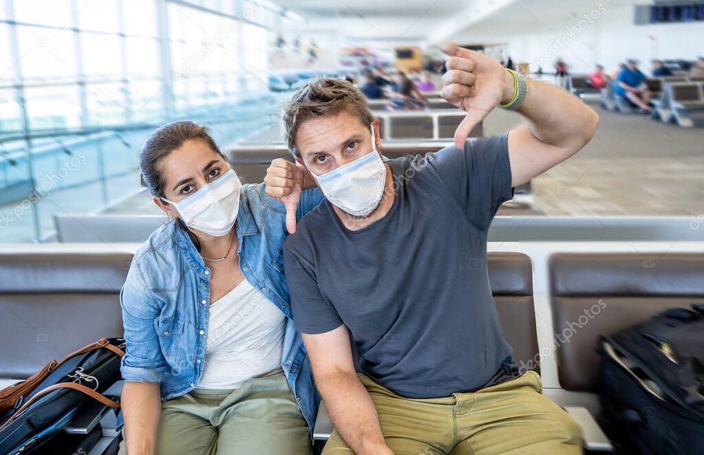 Coronavirus outbreak travel restrictions. Travelers with face mask at international airport affected by flights cancellations and travel ban. COVID-19 pandemic worldwide border closures and shutdowns.