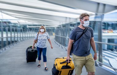 Coronavirus salgını, seyahat yasağı ve kısıtlamalar. Uluslararası havaalanındaki maskeli gezgin uçuş iptalinden etkilendi. COVID-19 salgını ve dünya çapında sınırlar kapanma ve kapanma.