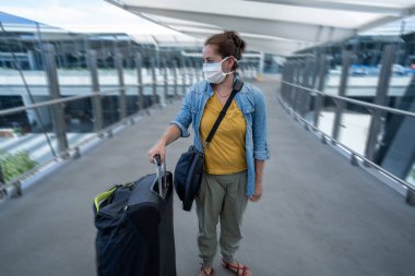 Coronavirus salgını, seyahat yasağı ve kısıtlamalar. Uluslararası havaalanındaki maskeli gezgin uçuş iptalinden etkilendi. COVID-19 salgını ve dünya çapında sınırlar kapanma ve kapanma.