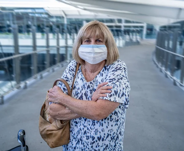 Coronavirus outbreak travel ban and restrictions. Traveler man with face mask at international airport affected by flight cancellation. COVID-19 pandemic and worldwide borders closures and shutdowns.