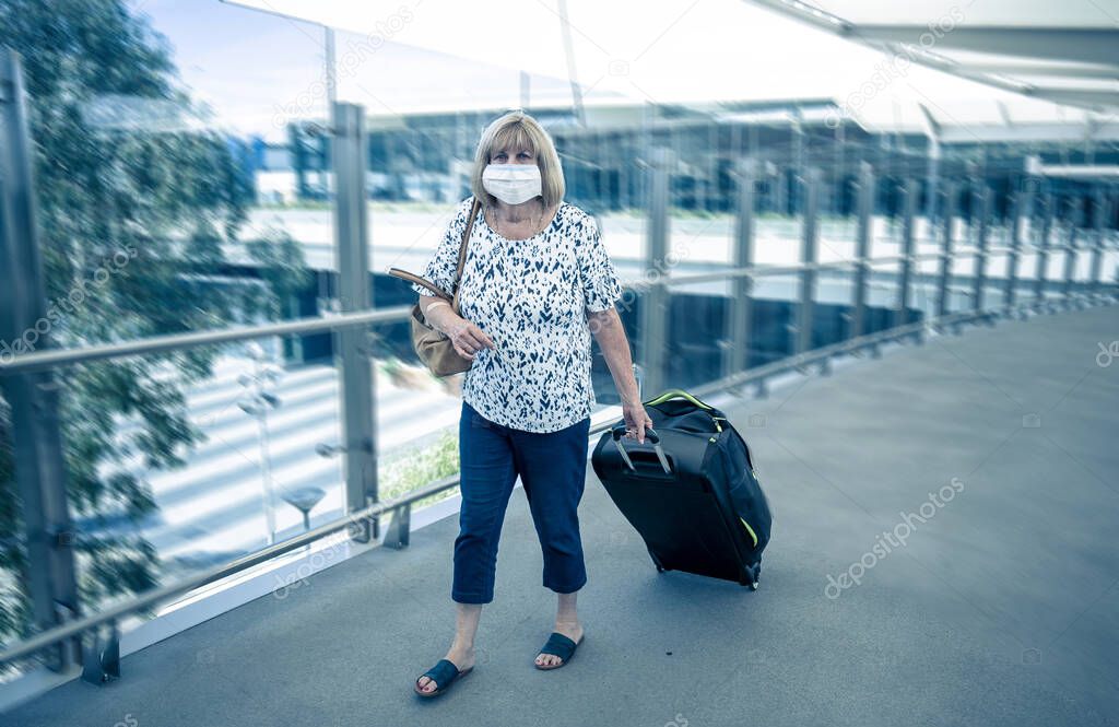 Coronavirus outbreak travel ban and restrictions. Traveler man with face mask at international airport affected by flight cancellation. COVID-19 pandemic and worldwide borders closures and shutdowns.