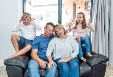 Stressed out parents struggling with having the children at home during Coronavirus self-isolation. Mother and father trying to cope with anxious kids during quarantine. COVID-19 Health crisis impact. clipart