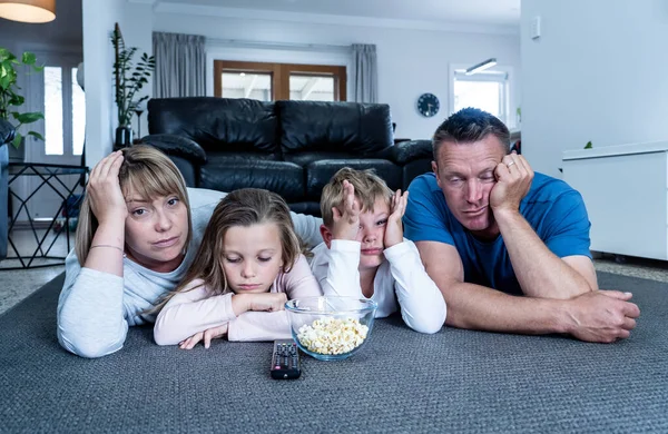 Coronavirus lockdow. Bored family watching tv helpless in isolation at home during quarantine COVID 19 Outbreak. Mandatory lockdowns and self isolation recommendations forces families stay home.