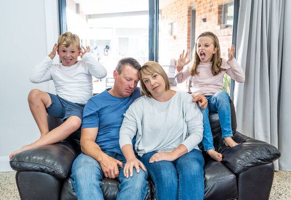 Stressed out parents struggling with having the children at home during Coronavirus self-isolation. Mother and father trying to cope with anxious kids during quarantine. COVID-19 Health crisis impact.