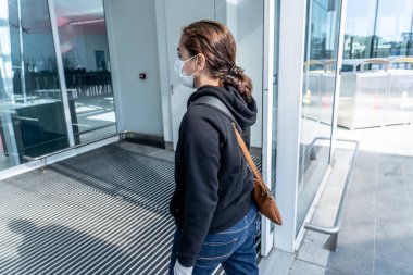 COVID-19 pandemik kısıtlamalar. Hükümetler Coronavirus 'un yayılmasını engellemek için seyahatleri kısıtladığından yabancı bir ülkede sıkışıp kaldıktan sonra, havaalanında eve dönmek için bekleyen genç kadın..