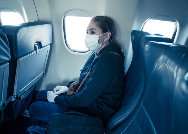 COVID-19 Pandemic border closures. Young woman on the plane returning home city after being stuck in a foreign country as governments have restricted travel to stop the coronavirus spread.