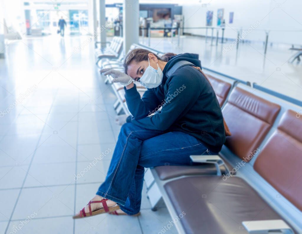 COVID-19 Pandemic restrictions. Young woman waiting at the airport to return home city after being stuck in a foreign country as governments have restricted travel to stop the coronavirus spread.