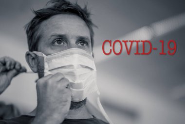COVID-19 hayat kurtarma kampanyası. Yüzüne maske takan genç bir adama yardım eden güçlü eller. Sağlıklı Kalın 'da, Coronavirüs' ün yayılmasını engelleyin, birlikte yapabiliriz ve dünya çapında sağlık uyarısı konsepti.