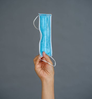 Coronavirus salgını. El ele tutuşup cerrahi maske takın. Virüsün yayılmasını önleyin, kendinizi ve diğerlerini COVID-19 ve PPE kişisel koruyucu malzeme eksikliğinden koruyun..