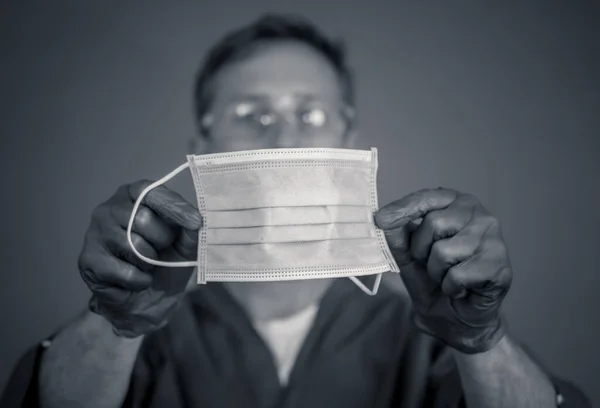 COVID-19. Doctor or nurse holding face surgical mask. Stop the virus spread, Protect yourself and others, and Help Hospitals with supplies and equipment for patient care and health worker safety.