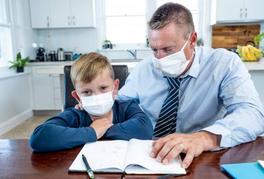 Coronavirus Salgını Okulu kapanır. Stresli ebeveyn uzaktan kumandayla başa çıkıyor ve COVID-19 salgınından endişe ediyor. Baba oğul karantinada çalışıyor ve evden öğreniyor..
