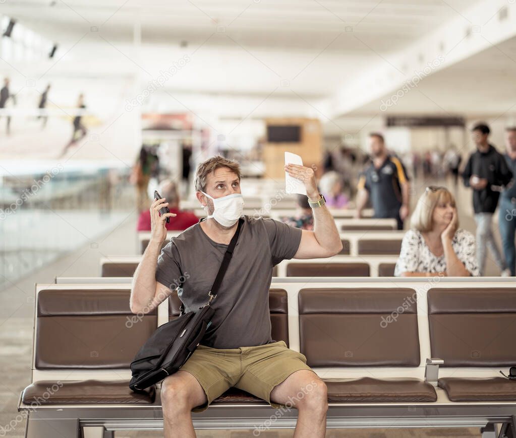COVID-19 worldwide borders closures.Traveler with face mask stuck in airport terminal after being denied entry to other countries. Passenger stranded in airport on his travel back to home country.