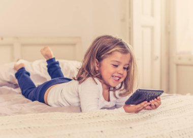 COVID-19 tecrit. Evde kal, bağlantıda kal ve e-öğrenim yap. Coronavirus karantinası sırasında cep telefonundan arayan ve ailesiyle görüntülü konuşma yapan küçük bir kız. İnternette öğretmenle telefonda konuşan bir çocuk..