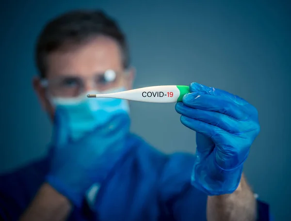 COVID-19 Outbreak. Doctor holding thermometer. Protect yourself and prevent the spread of the coronavirus. If you have symptoms, fever, cough and difficulty breathing, seek medical attention.
