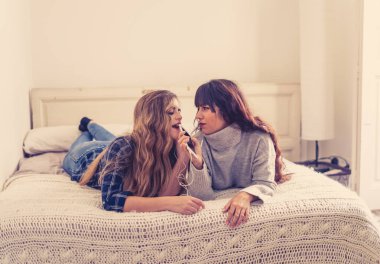 COVID-19 tecrit. Coronavirus sosyal mesafesi ve karantinası sırasında cep telefonuyla online müzik dinleyen kendinden emin ve pozitif kadın sevgililerin portresi. Evde kal, sağlıklı kal..