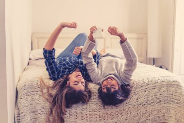 COVID-19 tecrit. Coronavirus sosyal mesafesi ve karantinası sırasında cep telefonuyla online müzik dinleyen kendinden emin ve pozitif kadın sevgililerin portresi. Evde kal, sağlıklı kal..