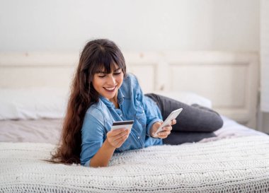 COVID-19 Salgını. Kapatma ve online alışveriş. Kredi kartı kullanan çekici genç bir kadın Coronavirus tecridi ve sosyal uzaklık süresince evde internet üzerinden yemek alıyor..