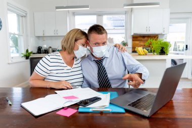 Coronavirus ekonomik durgunluğu. Karantina süresince ev ekonomisi ve küçük işletme borçları yüzünden kendilerini izole eden maskeli stresli bir çift. COVID-19 pandemik Küresel Ekonomik Krizin Etkisi.