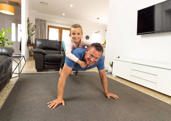 Covid 19关闭 在检疫期间 父女俩快乐地一起锻炼 家人在室内做体育活动很开心 呆在家里 锻炼身体 自理治疗头孢病毒的隔离 — 图库照片