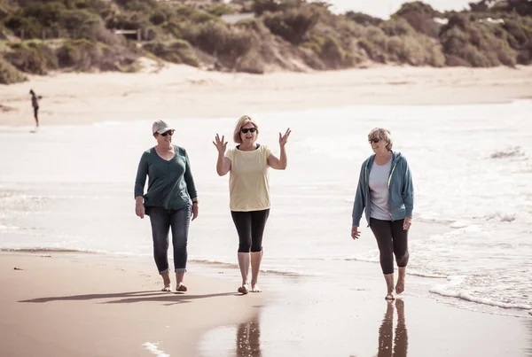三位年长的退休妇女从养老院一起走在海滩上 在户外活动中锻炼希望 并在科罗纳维勒斯闭锁的概念之后恢复生命 — 图库照片