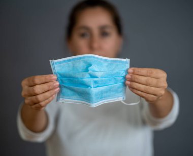Coronavirus salgını. El ele tutuşup cerrahi maske takın. Virüsün yayılmasını önleyin, kendinizi ve diğerlerini COVID-19 ve PPE kişisel koruyucu malzeme eksikliğinden koruyun..
