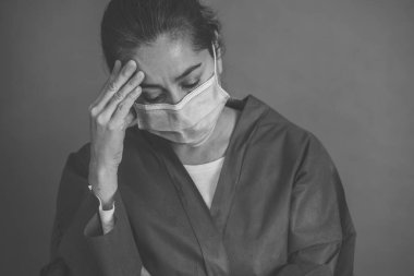 COVID-19. Koronavirüsün enfekte olduğu vakalar ve ölü sayıları artarken yorgun düşmüş doktor endişeli görünüyor. Duygusal stres, sağlık çalışanlarının desteğe, kişisel koruma ekipmanlarına ve tıbbi malzemelere ihtiyacı olması..