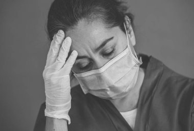 COVID-19. Koronavirüsün enfekte olduğu vakalar ve ölü sayıları artarken yorgun düşmüş doktor endişeli görünüyor. Duygusal stres, sağlık çalışanlarının desteğe, kişisel koruma ekipmanlarına ve tıbbi malzemelere ihtiyacı olması..