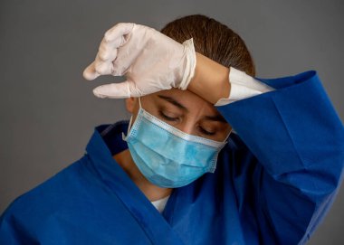 COVID-19. Koronavirüsün enfekte olduğu vakalar ve ölü sayıları artarken yorgun düşmüş doktor endişeli görünüyor. Duygusal stres, sağlık çalışanlarının desteğe, kişisel koruma ekipmanlarına ve tıbbi malzemelere ihtiyacı olması..