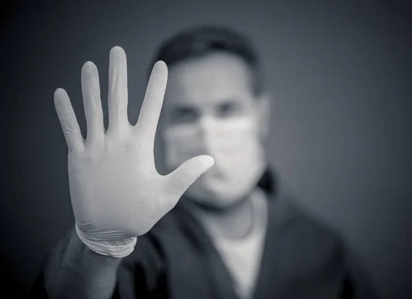 Covid 19爆发 帮助阻止病毒的传播 男医生或护士戴着面部外科口罩和手套Ppe 手部呈停止姿势 注意安全 保护好自己保护好他人 — 图库照片