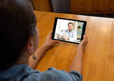 COVID-19 çevrimiçi tıbbi konsültasyon. Online erkek doktorla sanal bir randevuda olan kadın Coronavirus pandemik tecrit ve sosyal uzaklık merkezinden sağlık tavsiyesi ve tıbbi bakım alıyor..