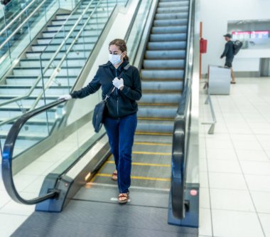 COVID-19 pandemik kısıtlamalar. Hükümetler Coronavirus 'un yayılmasını engellemek için seyahatleri kısıtladığından yabancı bir ülkede sıkışıp kaldıktan sonra, havaalanında eve dönmek için bekleyen genç kadın..