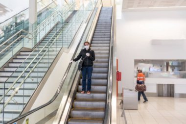 COVID-19 pandemik kısıtlamalar. Hükümetler Coronavirus 'un yayılmasını engellemek için seyahatleri kısıtladığından yabancı bir ülkede sıkışıp kaldıktan sonra, havaalanında eve dönmek için bekleyen genç kadın..