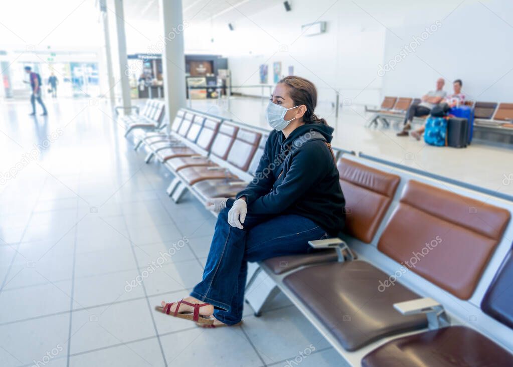 COVID-19 Pandemic restrictions. Young woman waiting at the airport to return home city after being stuck in a foreign country as governments have restricted travel to stop the coronavirus spread.