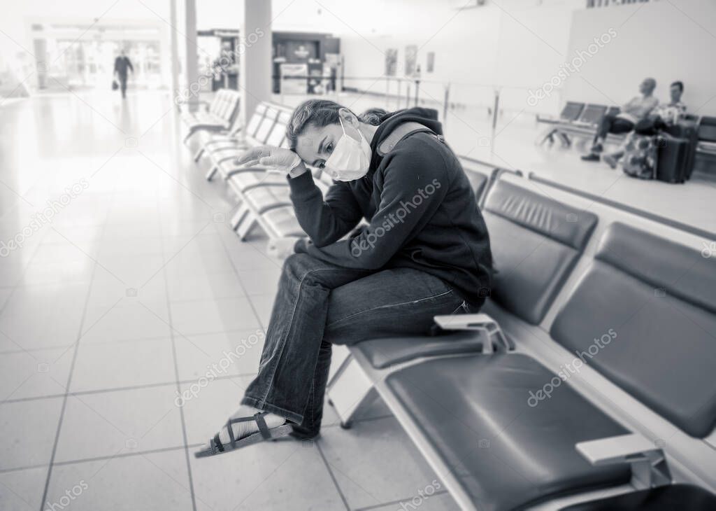 COVID-19 Pandemic restrictions. Young woman waiting at the airport to return home city after being stuck in a foreign country as governments have restricted travel to stop the coronavirus spread.