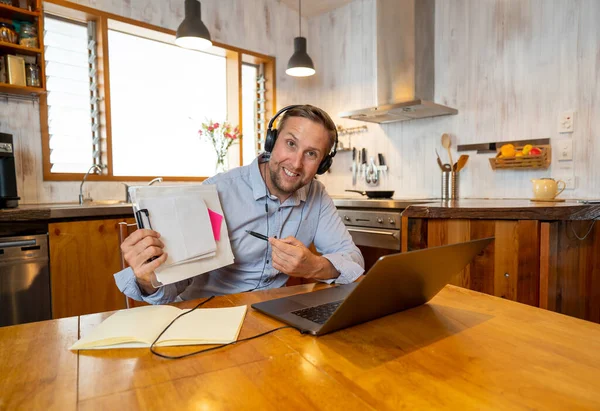 Happy business man on laptop working from home. Freelancer on computer on a video conference with employees working remotely in coronavirus Lockdown, Social Distancing and New Normal concept.