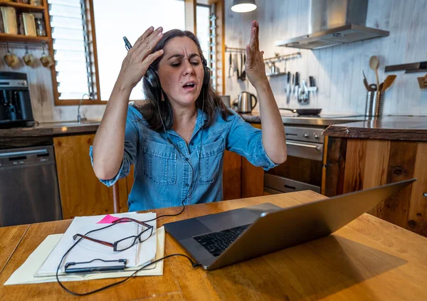 穿着紧绷的女商人坐在笔记本电脑上从家里工作 看起来焦虑 不知所措 在远离社会的过程中 完全是女性在从事远程工作 精神健康和锁闭验尸官 — 图库照片