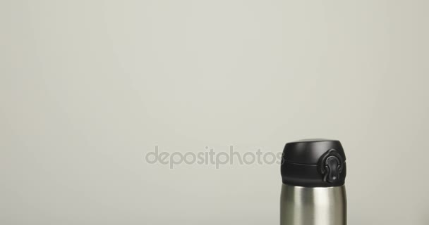 灰色の背景に革のバッグで熱マグカップを置く男の手のクローズ アップ — ストック動画